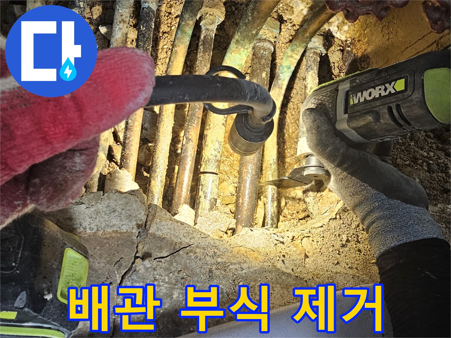 부식된 배관을 제거하기 위해 전동 공구를 사용하는 현장 사진