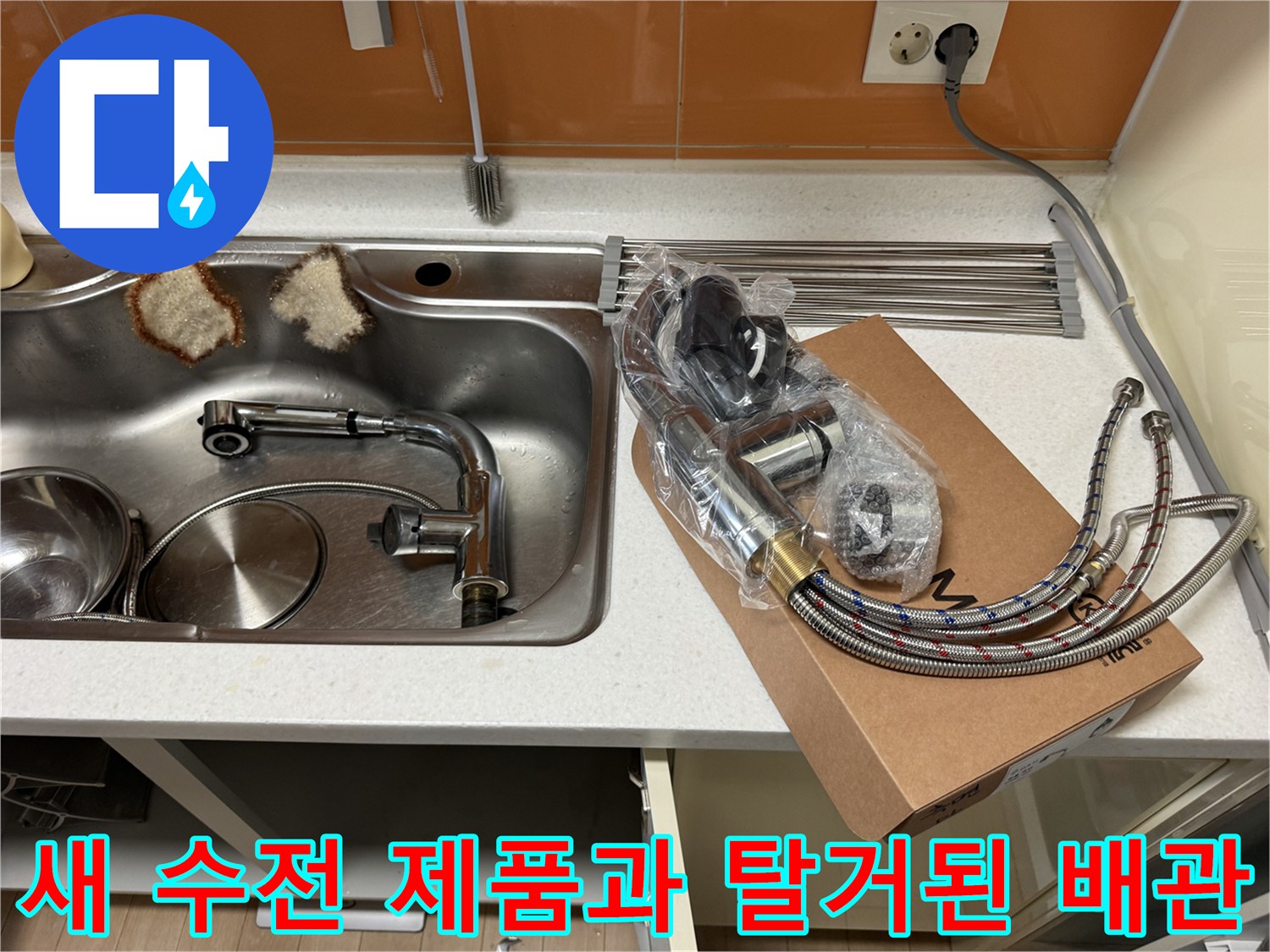 기존 싱크대 배관 옆에 놓인 새 수전 패키지