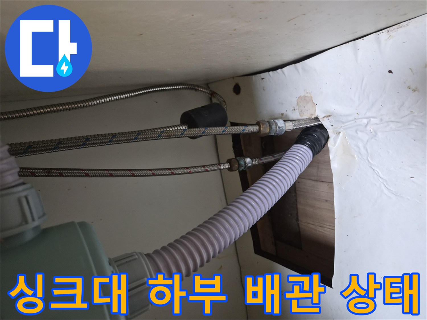 벽면으로 이어지는 은색 고압 호스와 흰색 자재의 연결 부위