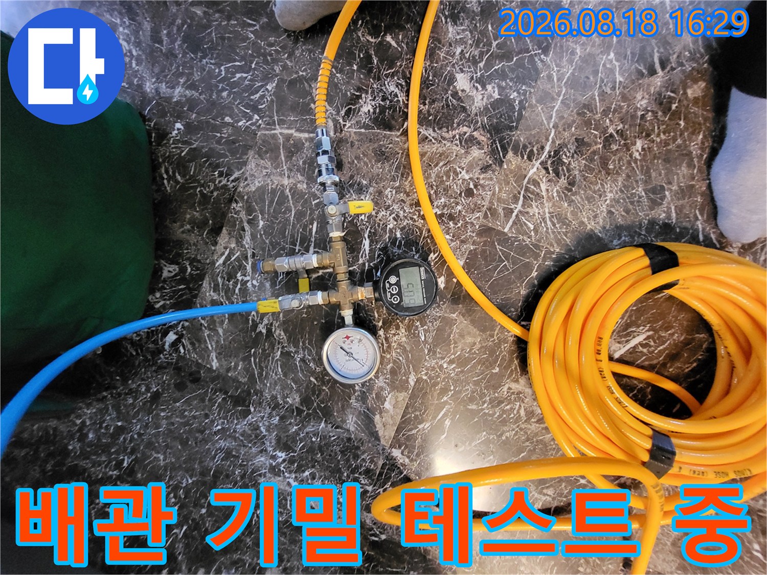 노란색 급수 호스와-압력 측정 장비가 배관에 연결되어 있는 상태입니다.