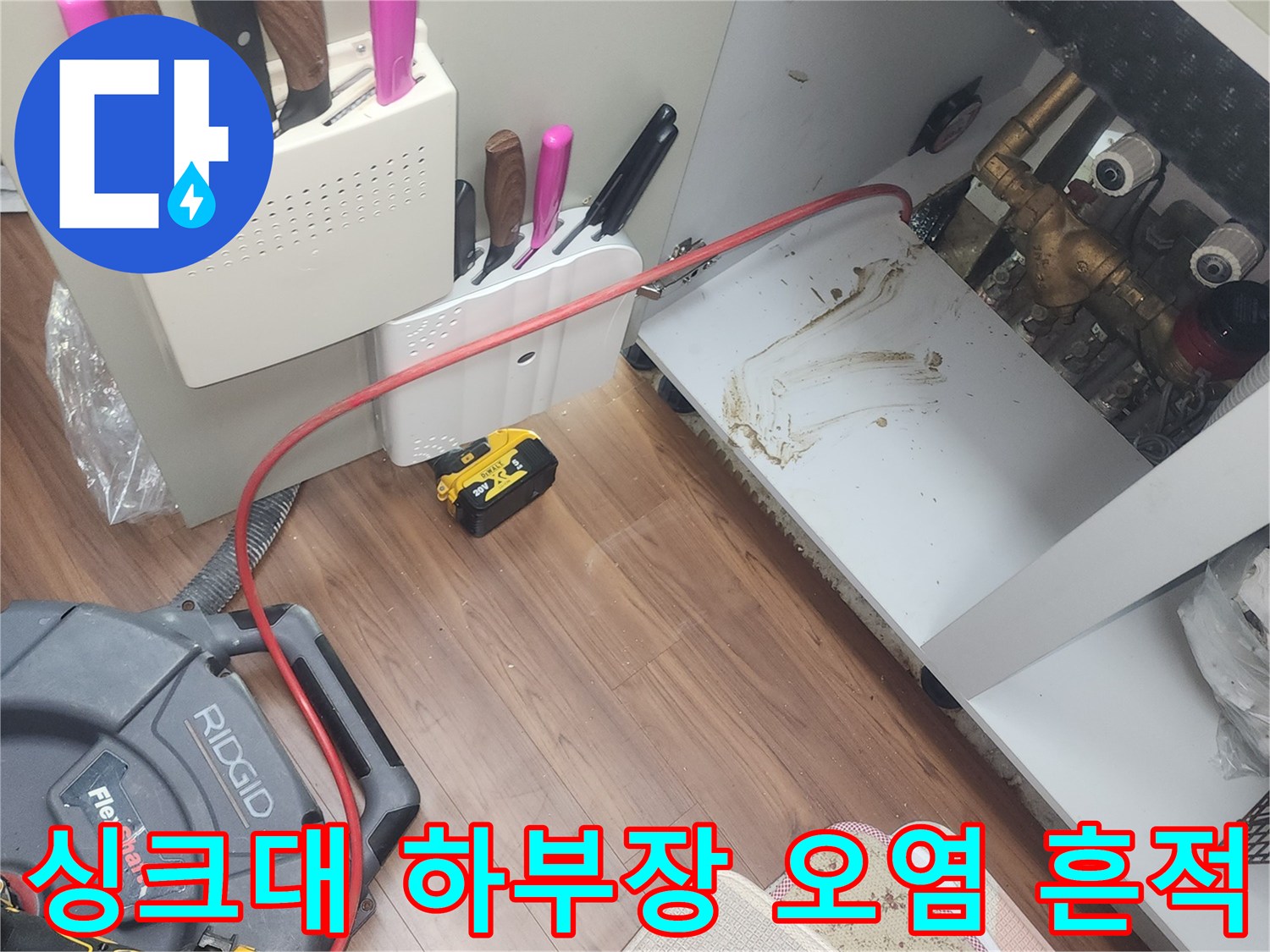 배관 주변에 물기가 남아있는 싱크대 하부 모습입니다.