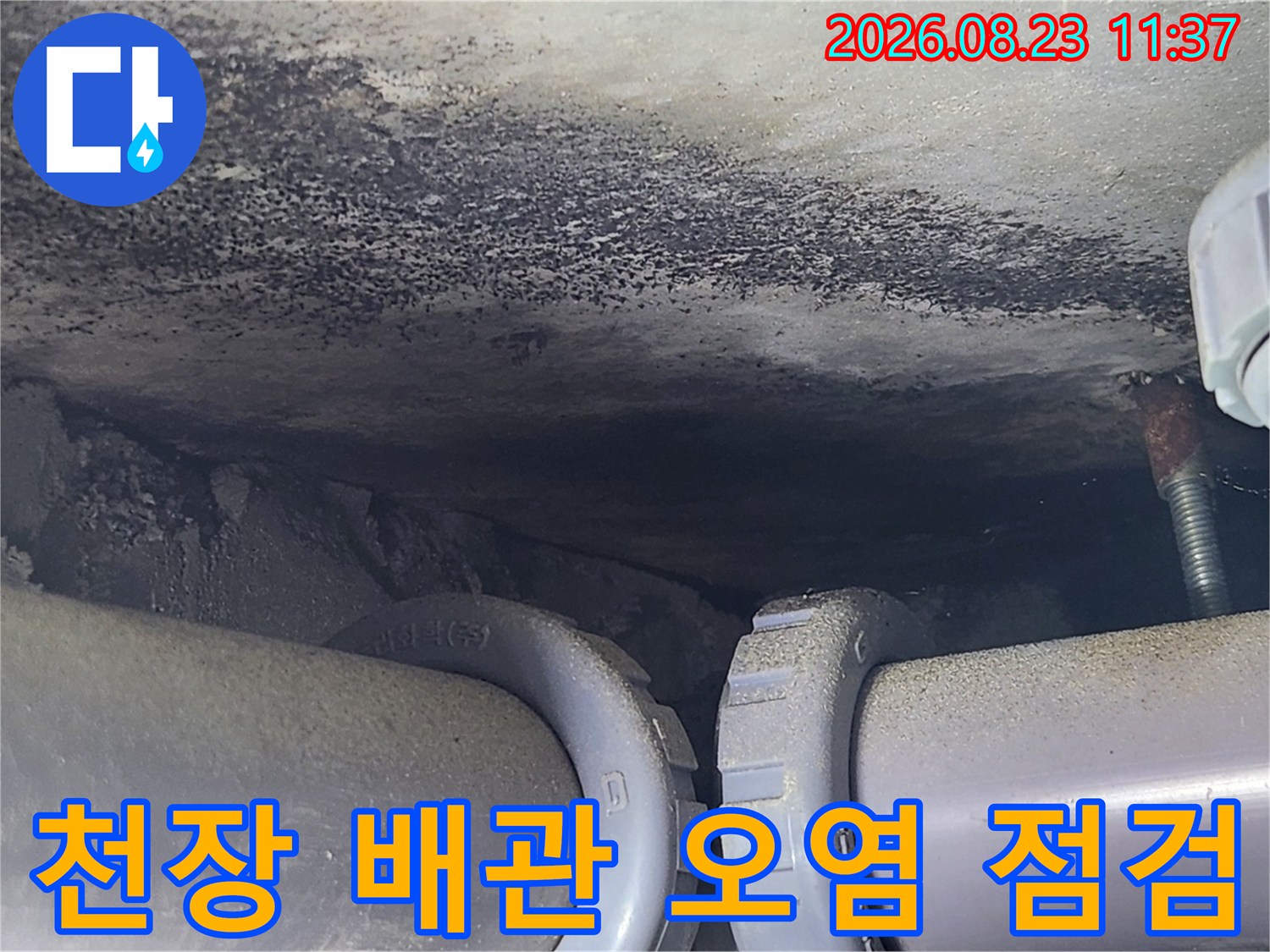 배관 상단 천장 마감재의 어두운 물자국과 습기 흔적