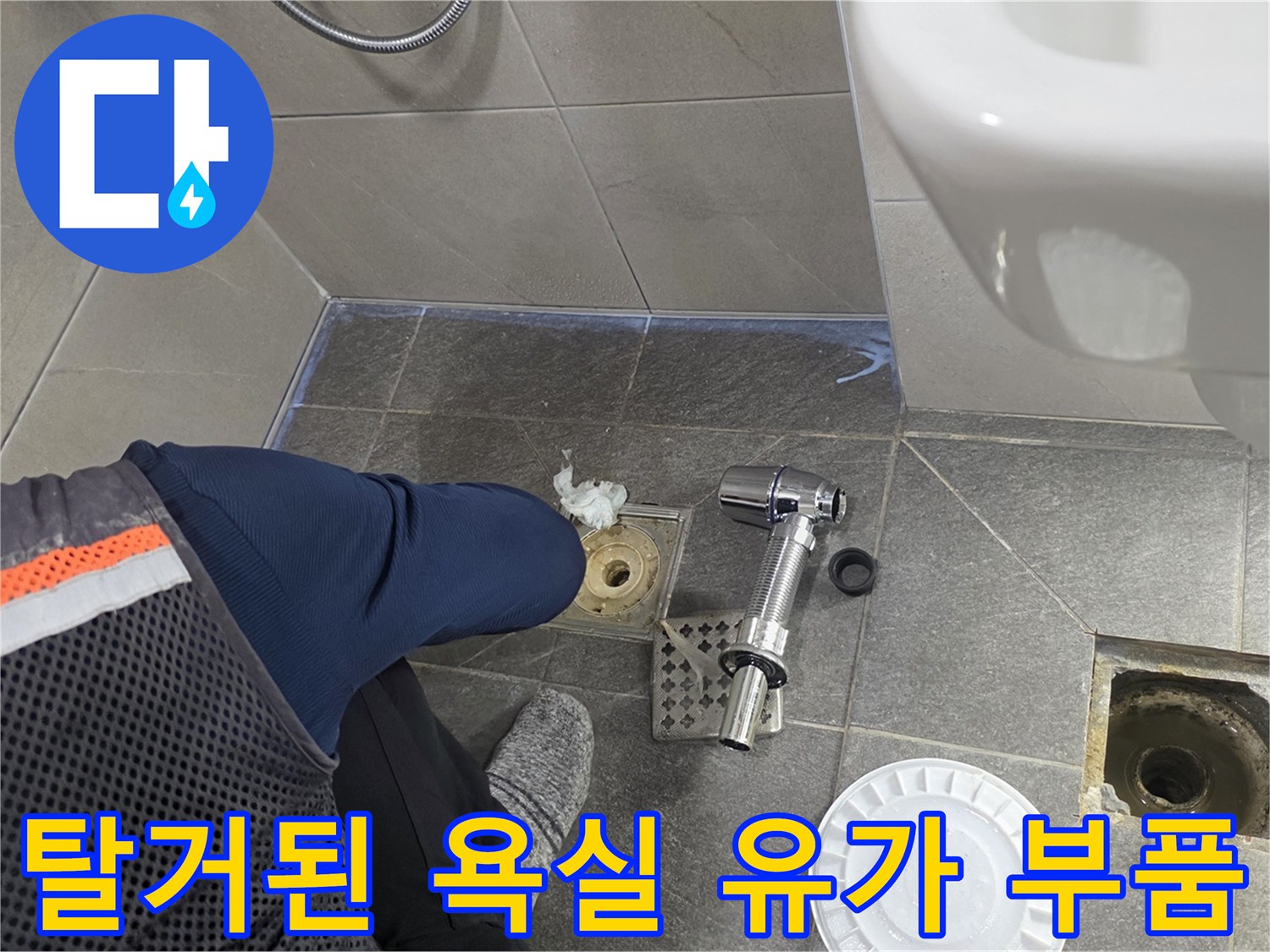 욕실 배수구 주변의 탈거된 금속 및 플라스틱 부속품들