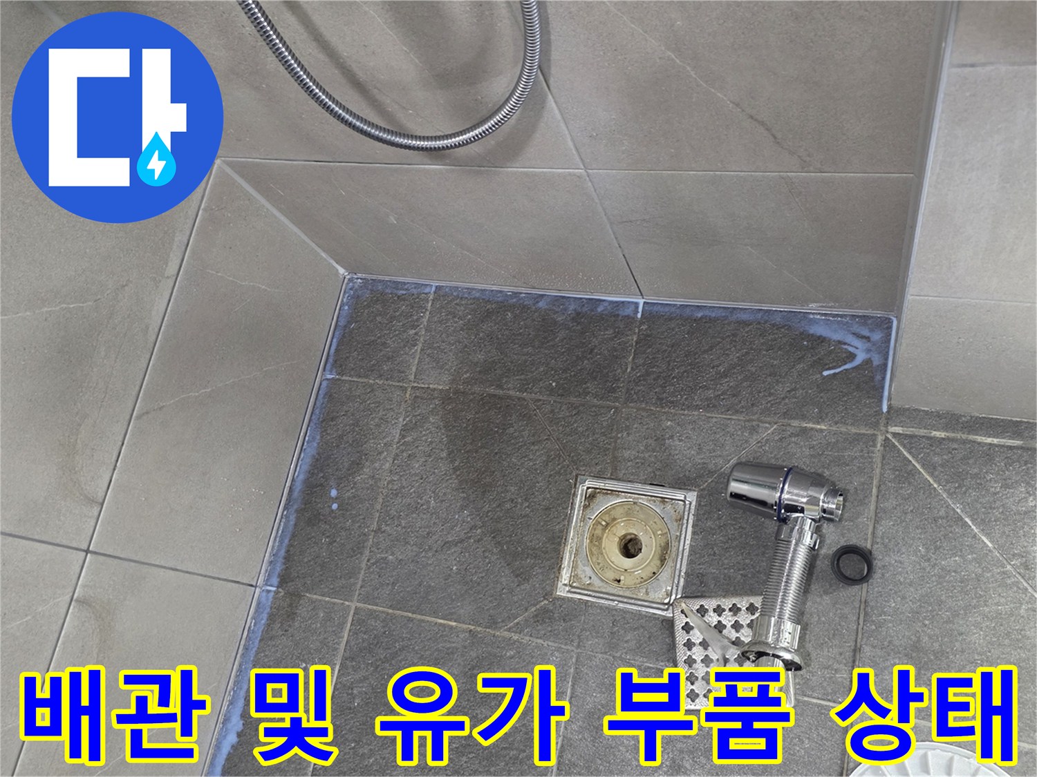 탈거된 배수구 유가와 노출된 바닥 배관의 근접 촬영