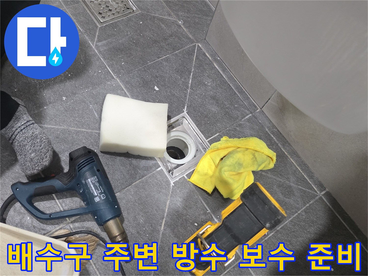 화장실 바닥 배수관 주변의 이물질을 제거하고 방수 작업을 진행하기 위해 정돈된 현장 상황