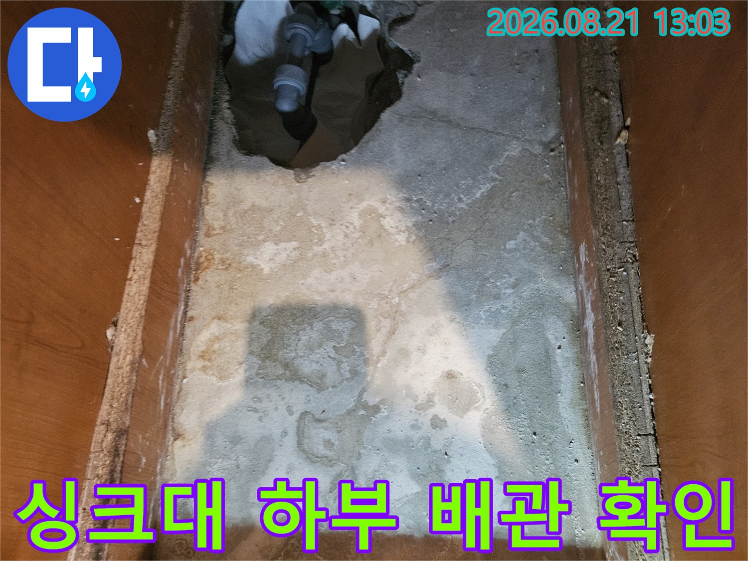 안양 동안구 아파트 싱크대 하부장 내부의 굴착된 벽면과 노출된 배관 상태