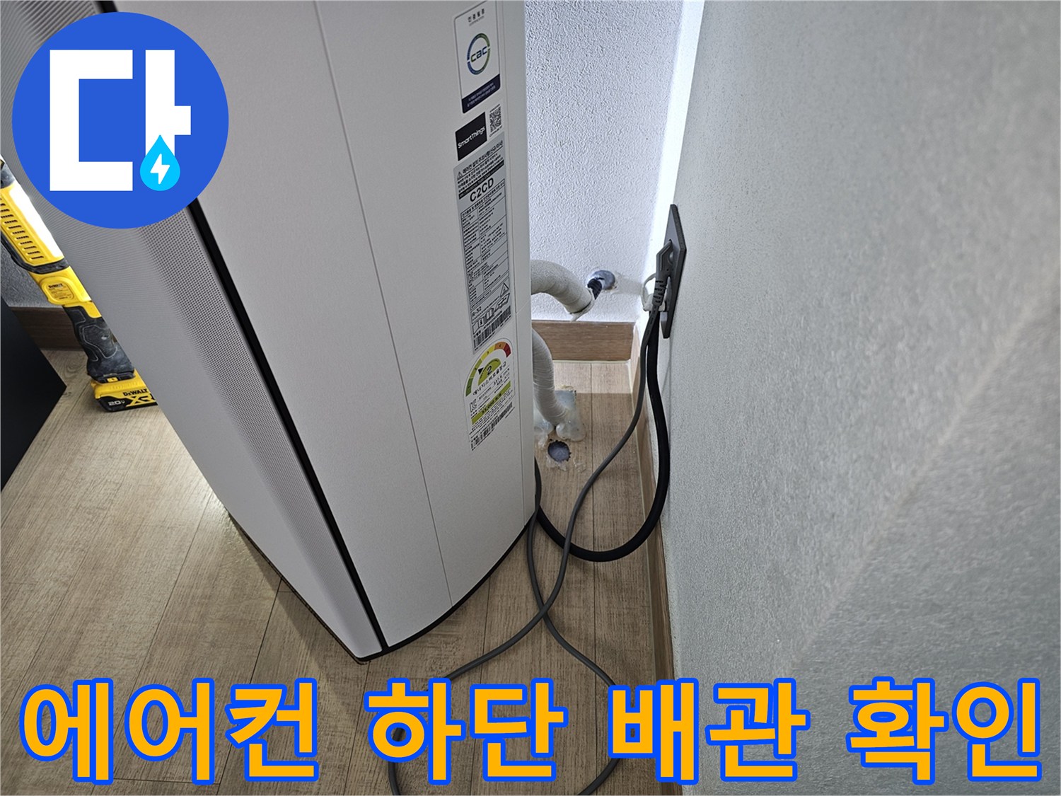 에어컨 본체 밑으로 연결된 흰색 드레인 호스 부위입니다.
