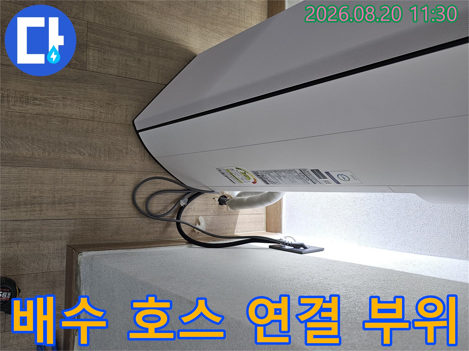 에어컨 하단부-배수 호스와 전선이 연결된 상세 모습입니다.