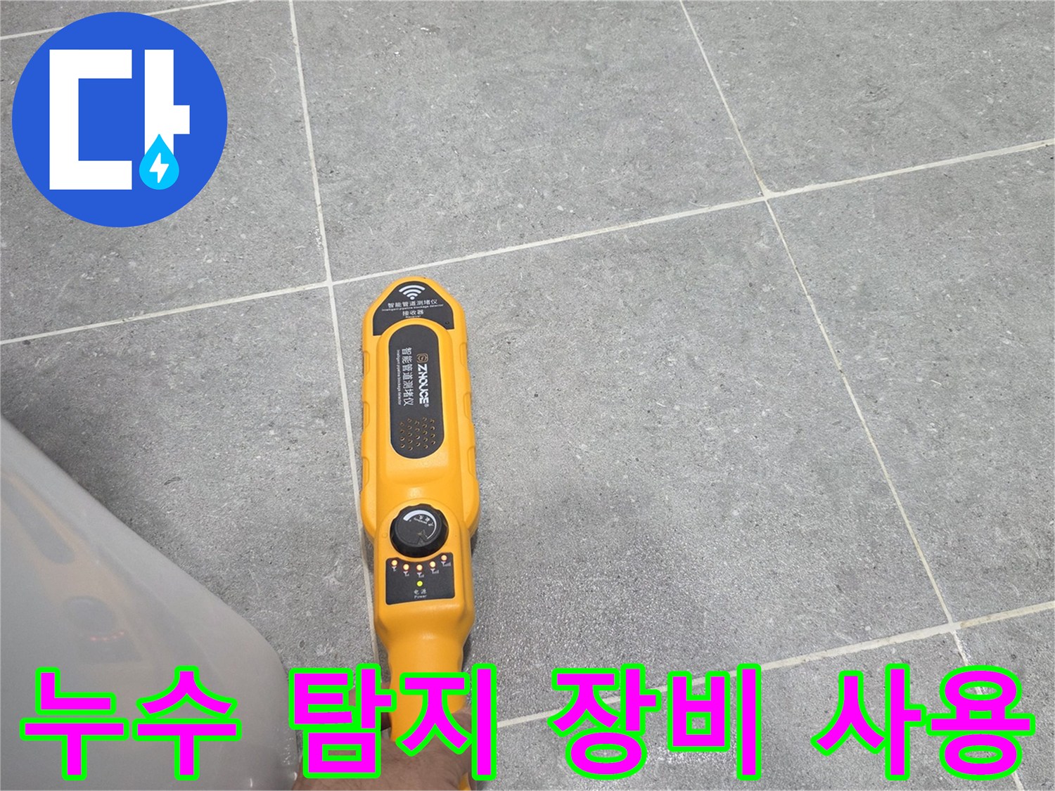 욕실 타일 위에서-누수 지점을 찾기 위해-탐지기를 사용하는 모습