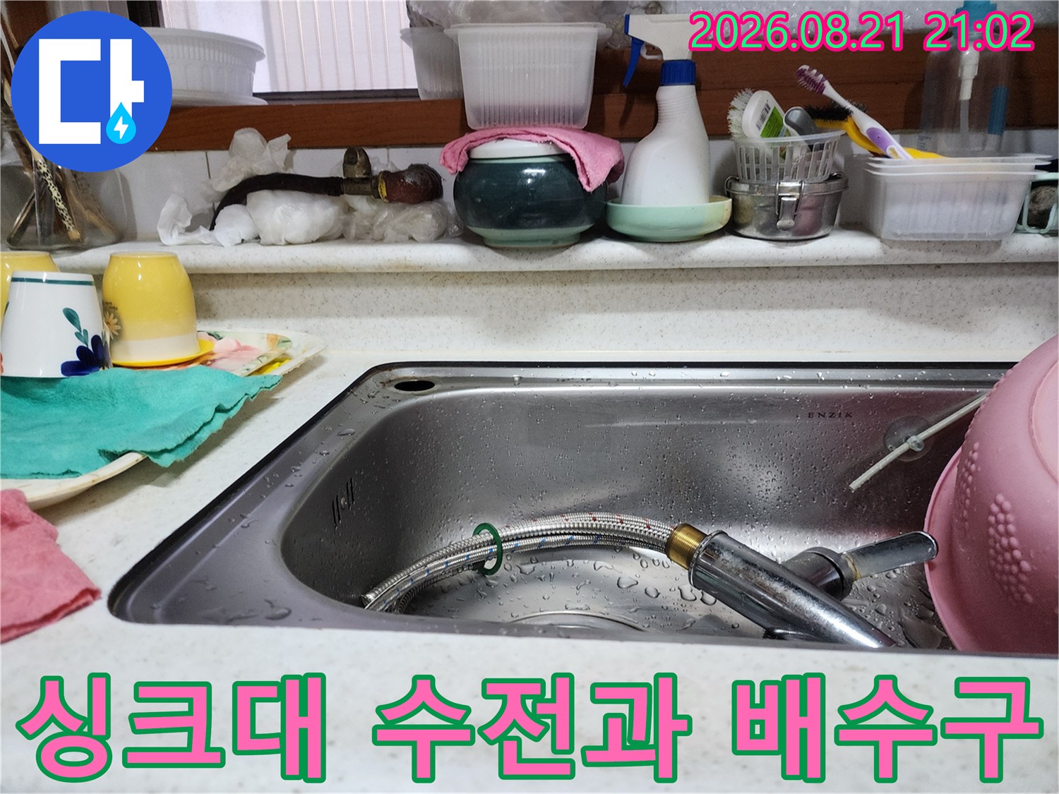 물기가 맺힌 스테인리스 싱크대와 스프레이형 수전의 모습