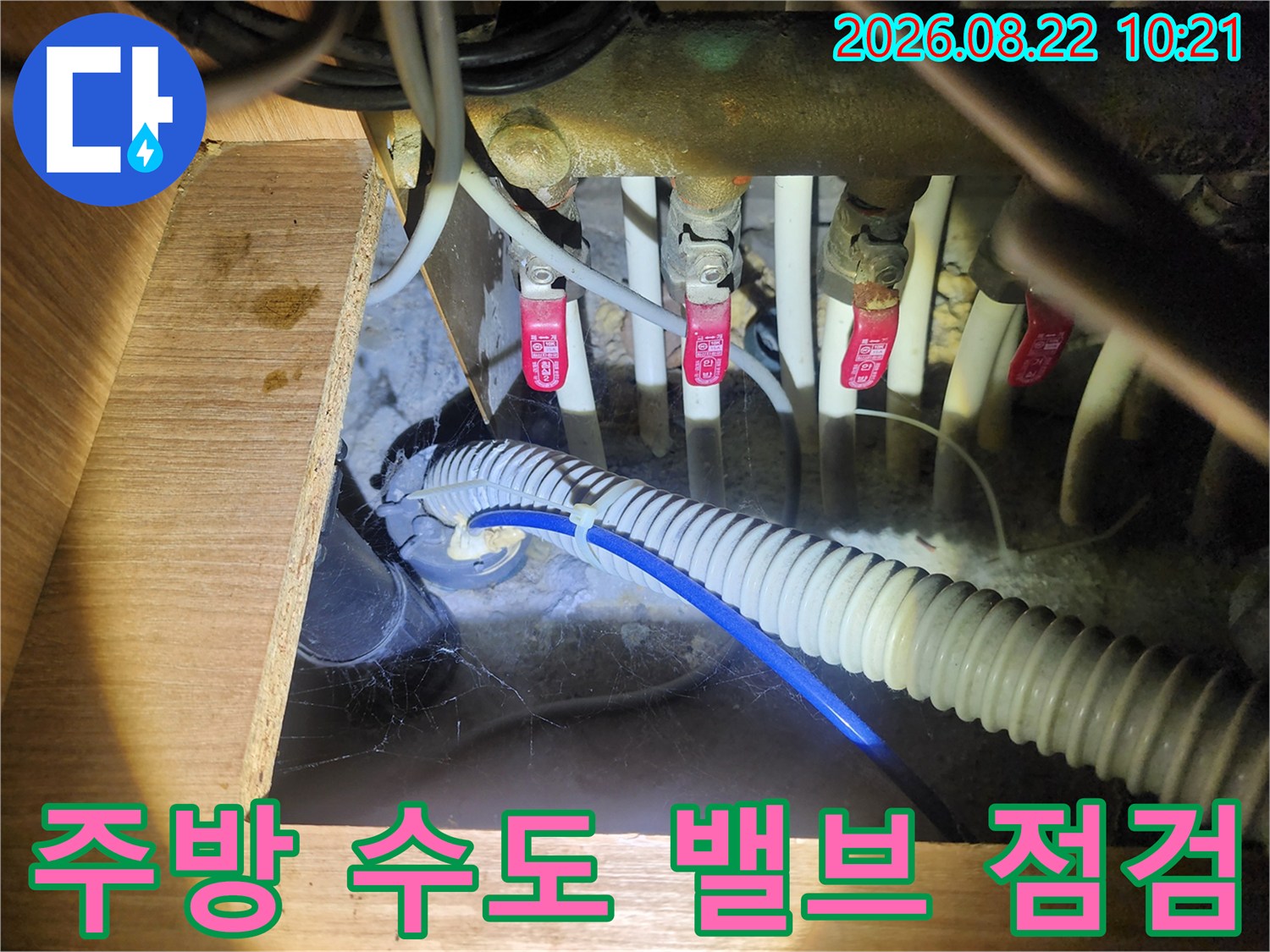 싱크대 하부장 내 수도 밸브와 배수 호스 연결 상태