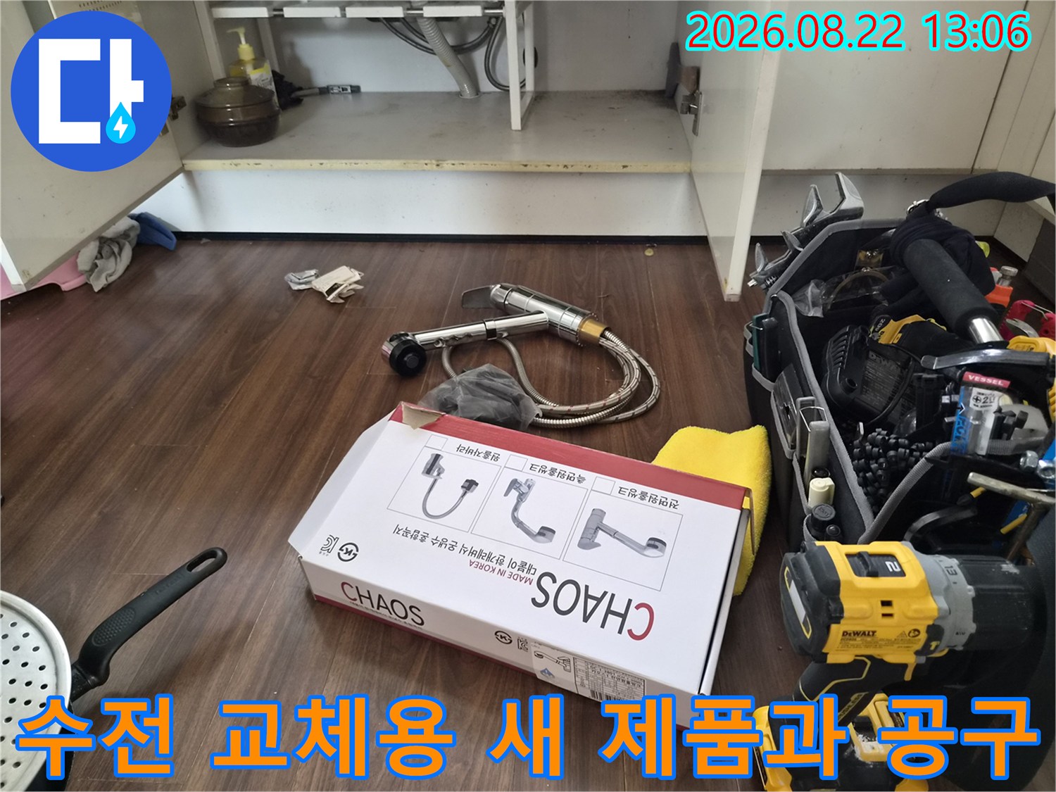 싱크대 하단 작업 공간에 놓인 새 수전 박스와 전동 드릴 장비