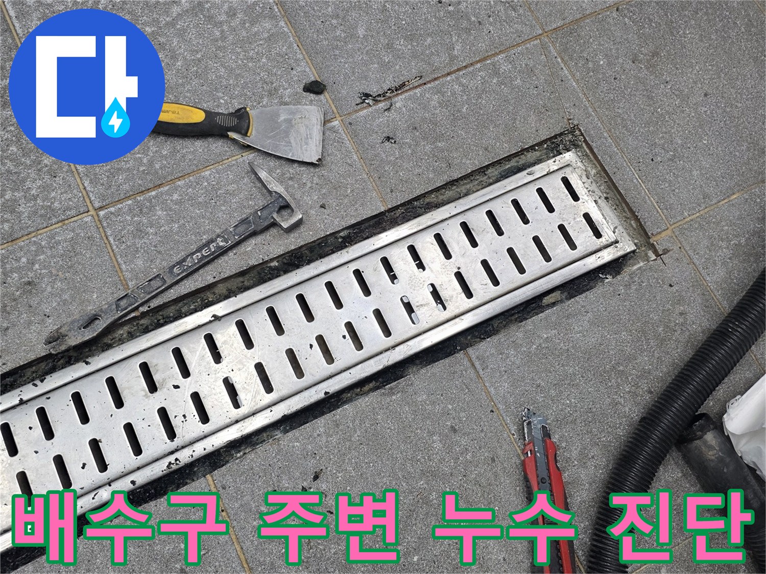 트렌치 덮개와 작업 도구가 놓여 있는 타일 바닥 사진