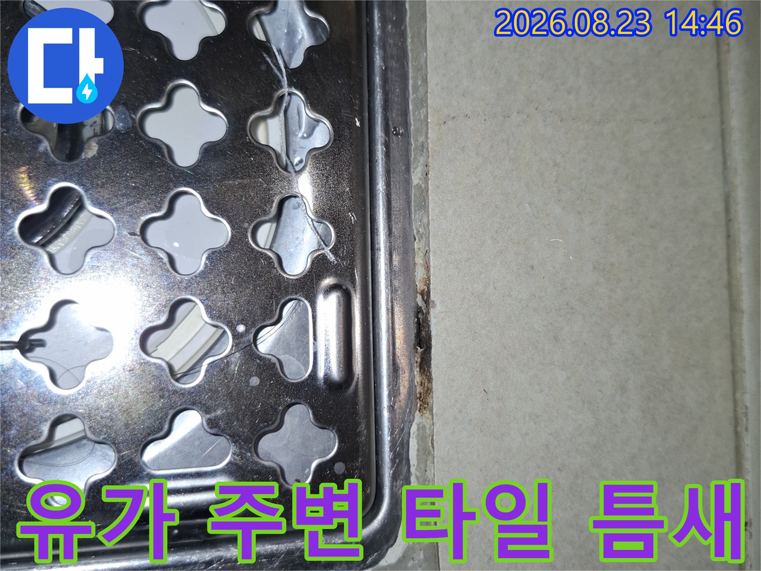 배수구 유가-타일 경계면의 오염과 틈새를 근접 촬영한 이미지입니다.