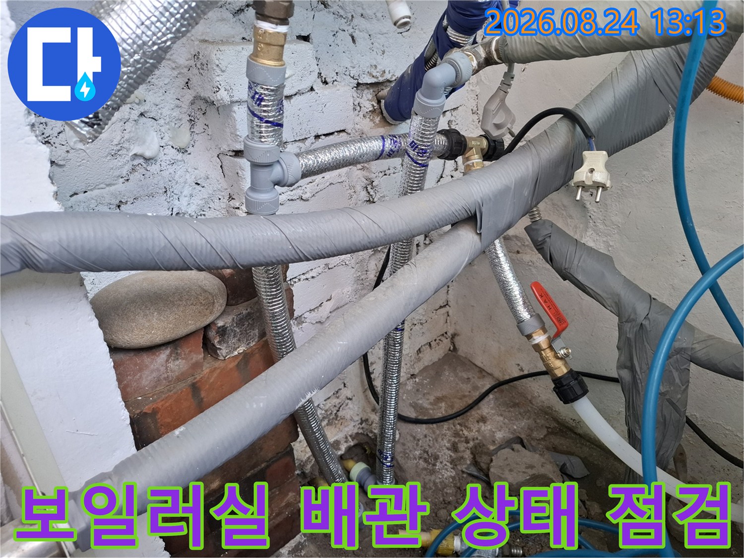 은색 보온재와 파란색 호스가 섞인 복잡한 보일러실 배관 구조