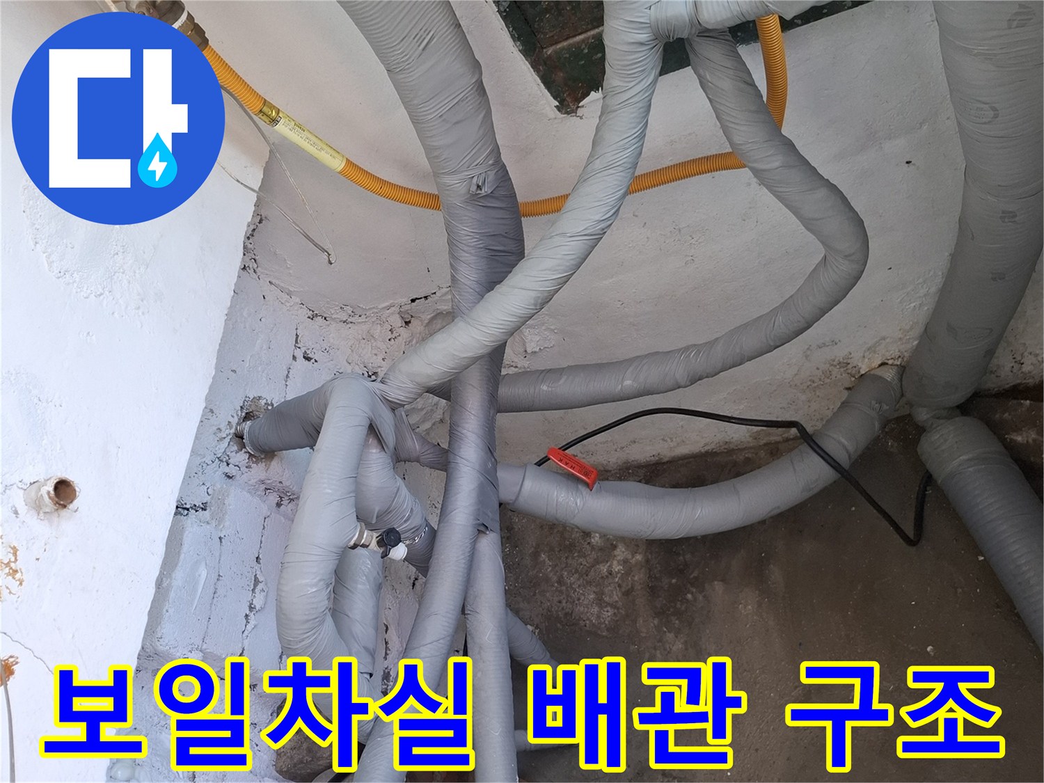 회색 보온재와 노란색 직수관이 얽혀 있는 보일러실 내부 배관 사진
