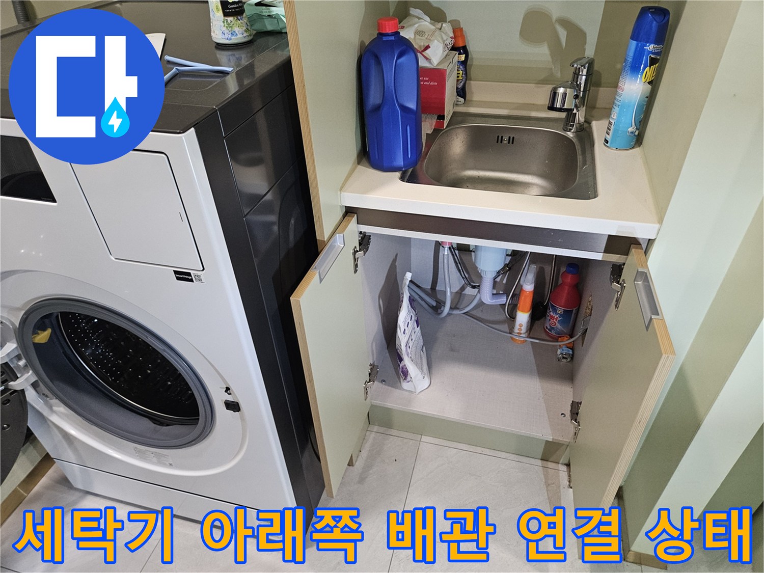 다용도실 수납칸 내부의 배관 라인과 세제 용품들