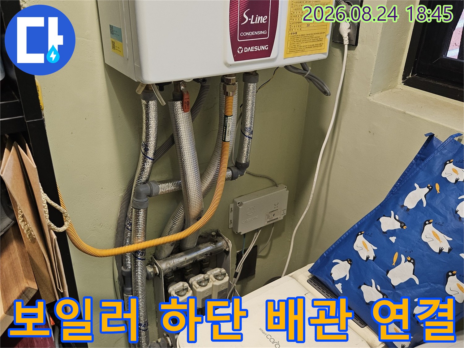 보일러와 은색 보온재로 감싸진 배관의 모습입니다.