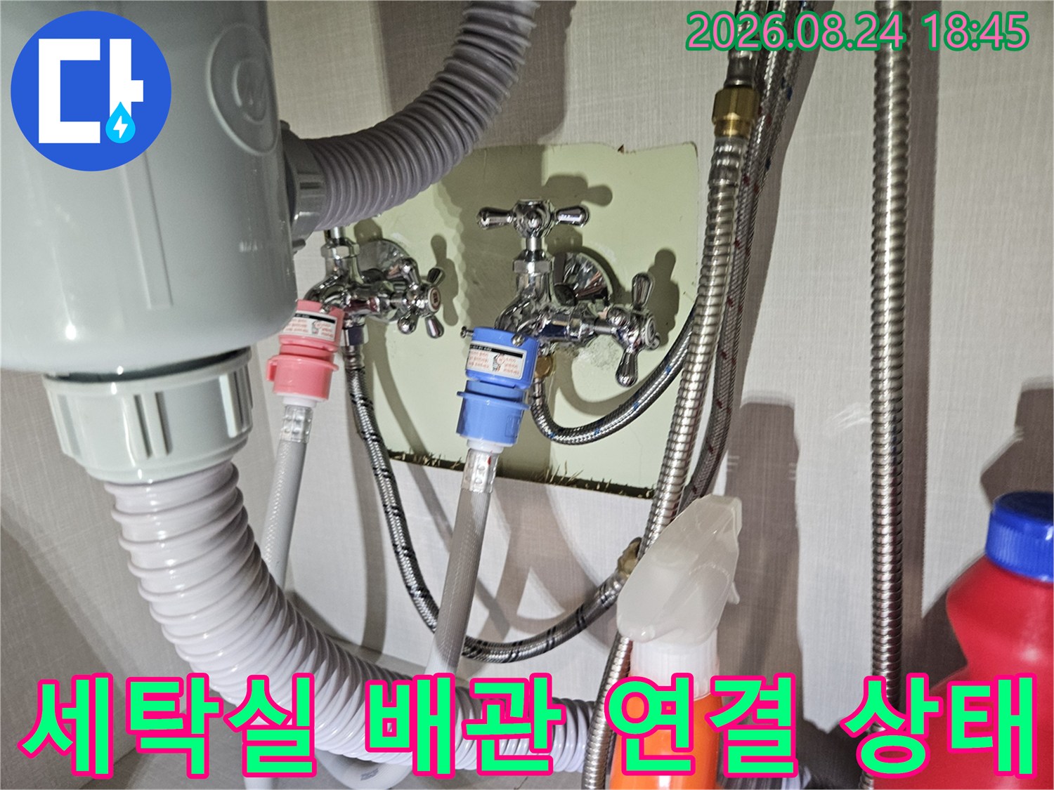 수도꼭지와 세탁 호스가 연결된 배관 설비의 상세 모습입니다.
