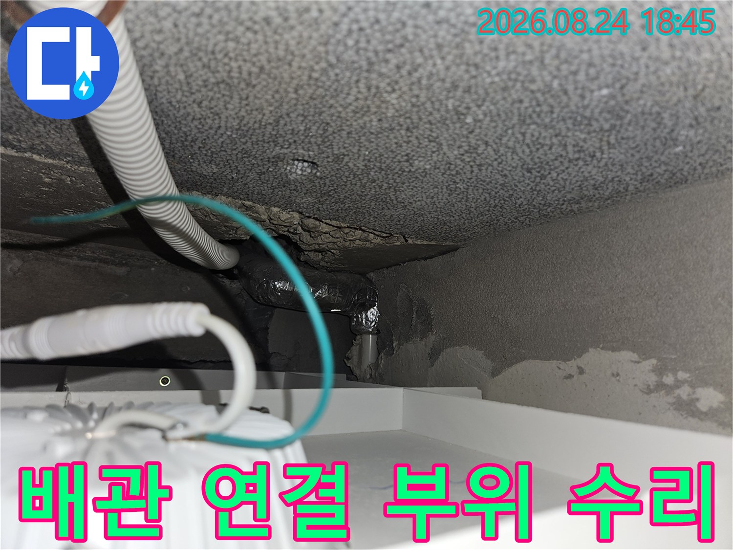 습기가 찬 계단 벽면 배관 연결 부위의 보수 작업 상태