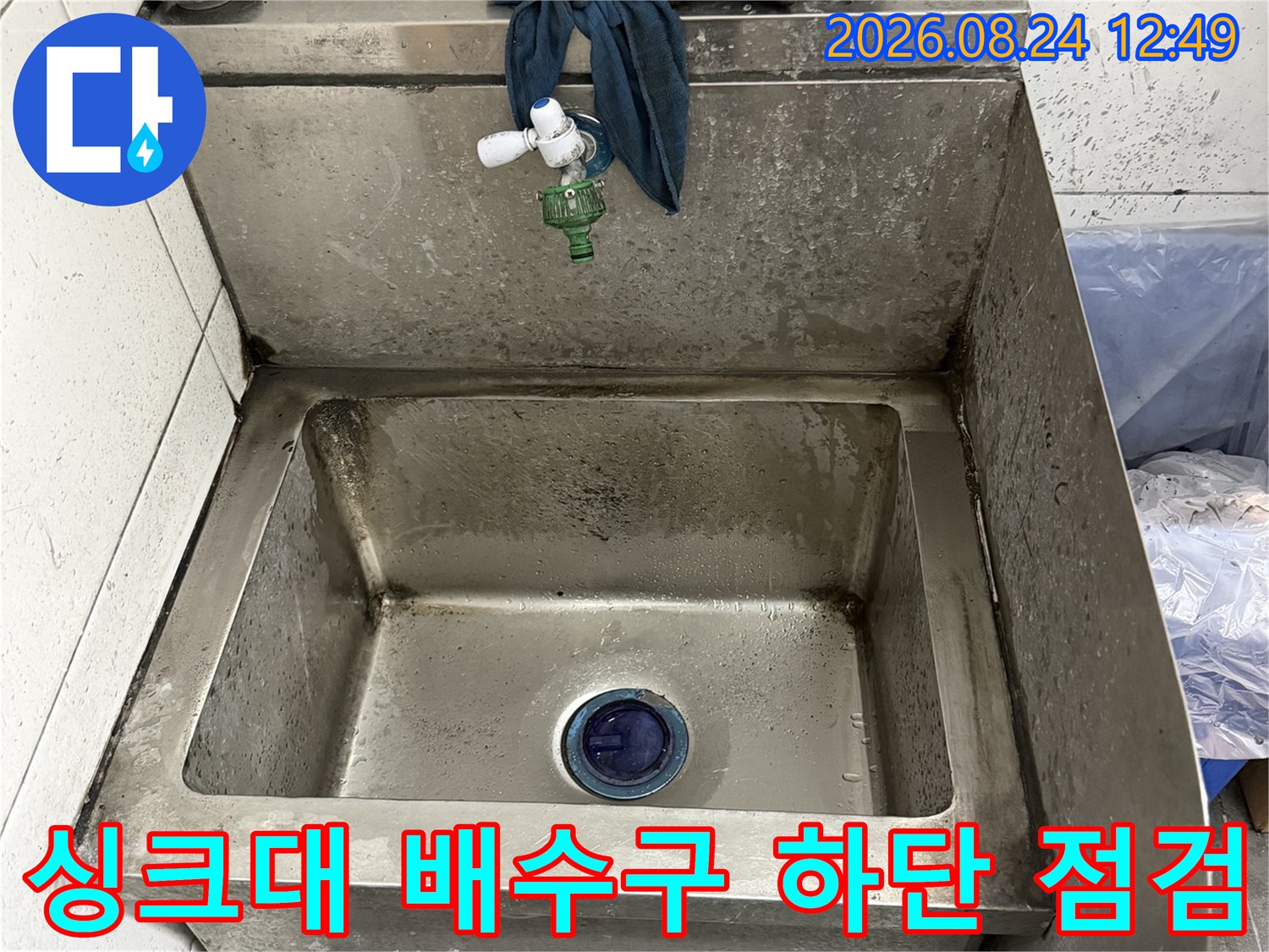 스테인리스 싱크대 내부의 배수 구멍과 주변 배관 구조