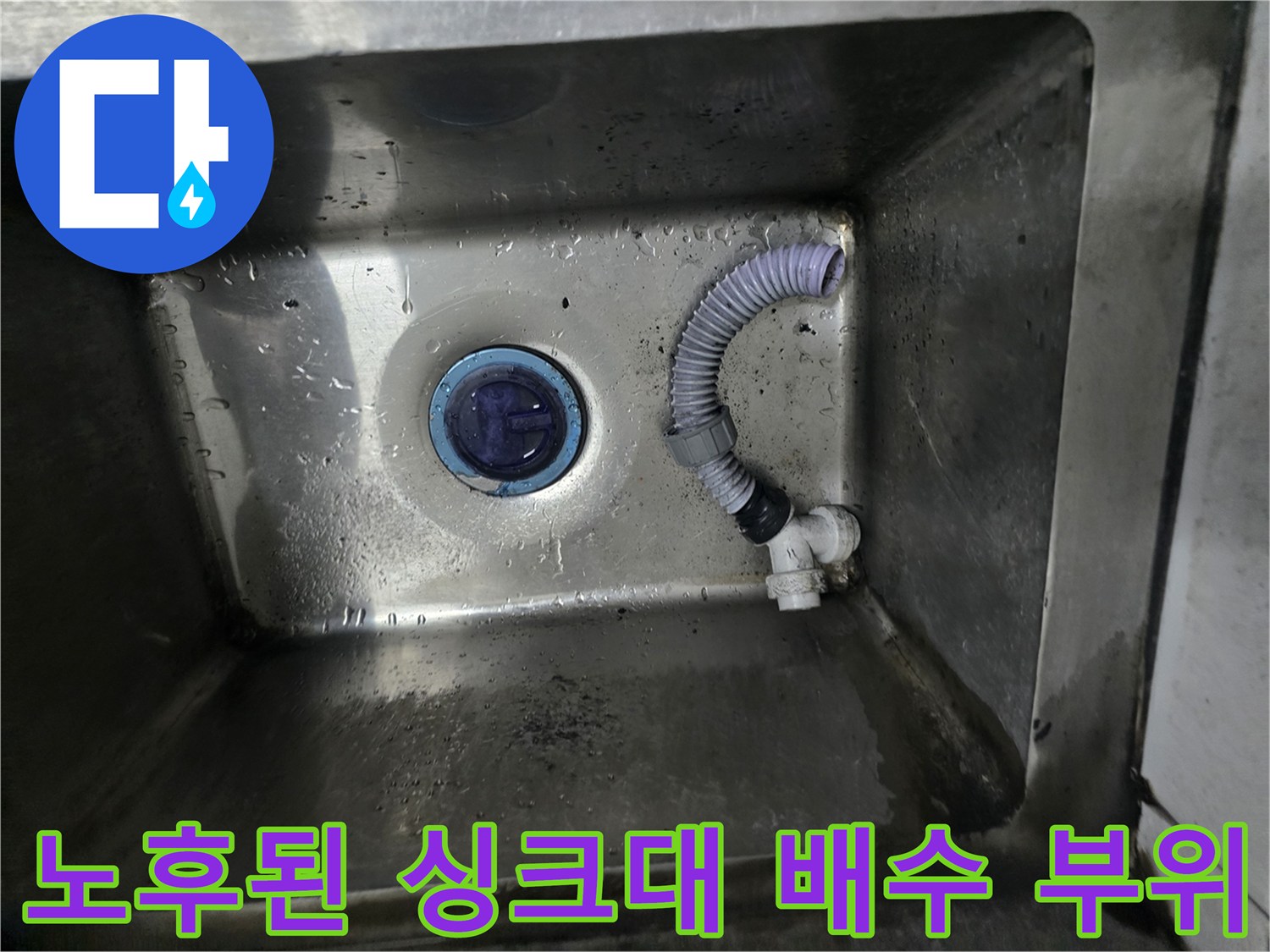 식당 싱크대 내부의 틈이 벌어진 배수관 연결 상태를 보여줍니다.
