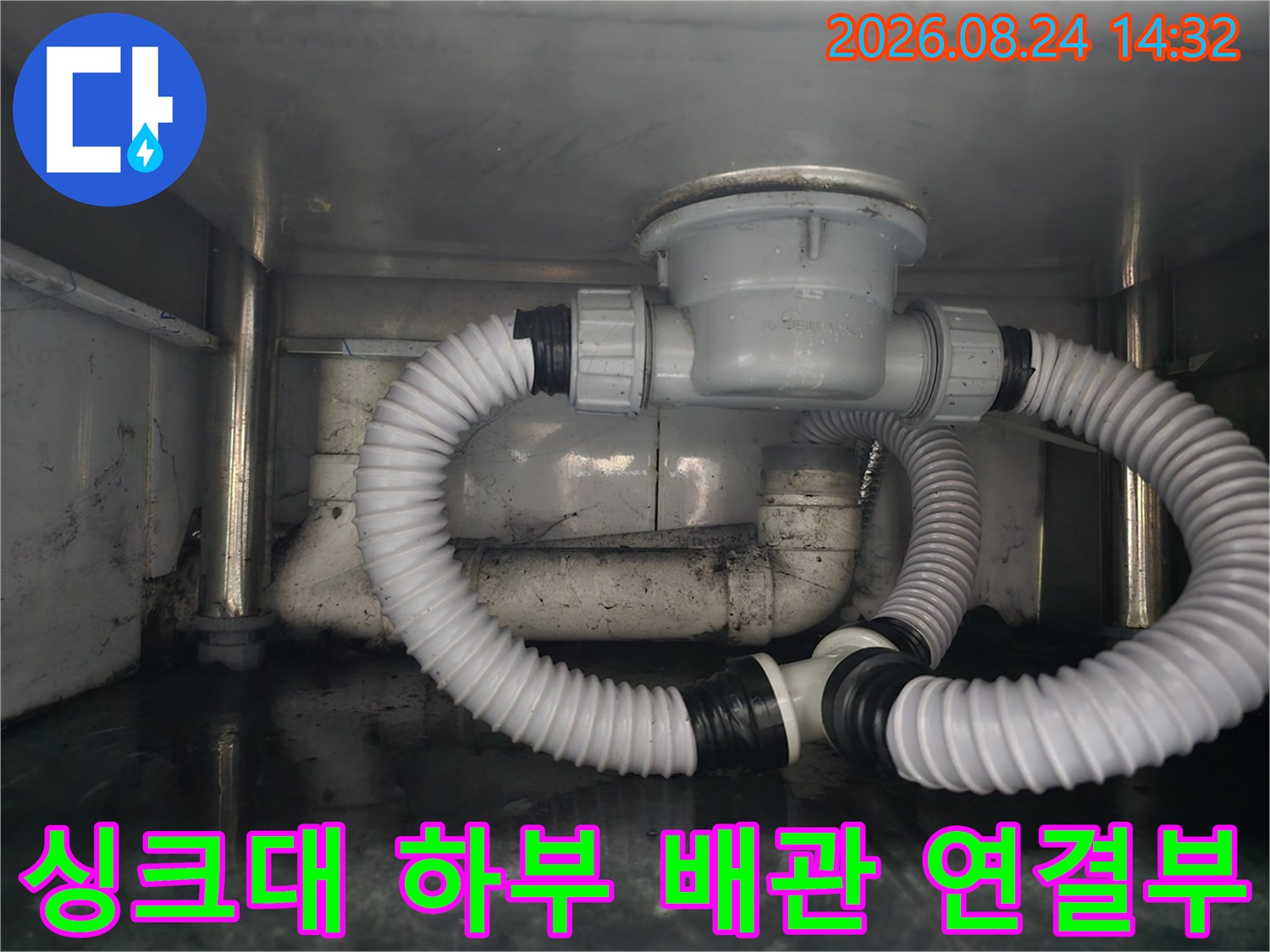 식당 싱크대 아래쪽의 흰색 배수용 주름관과 배수통 구조입니다.