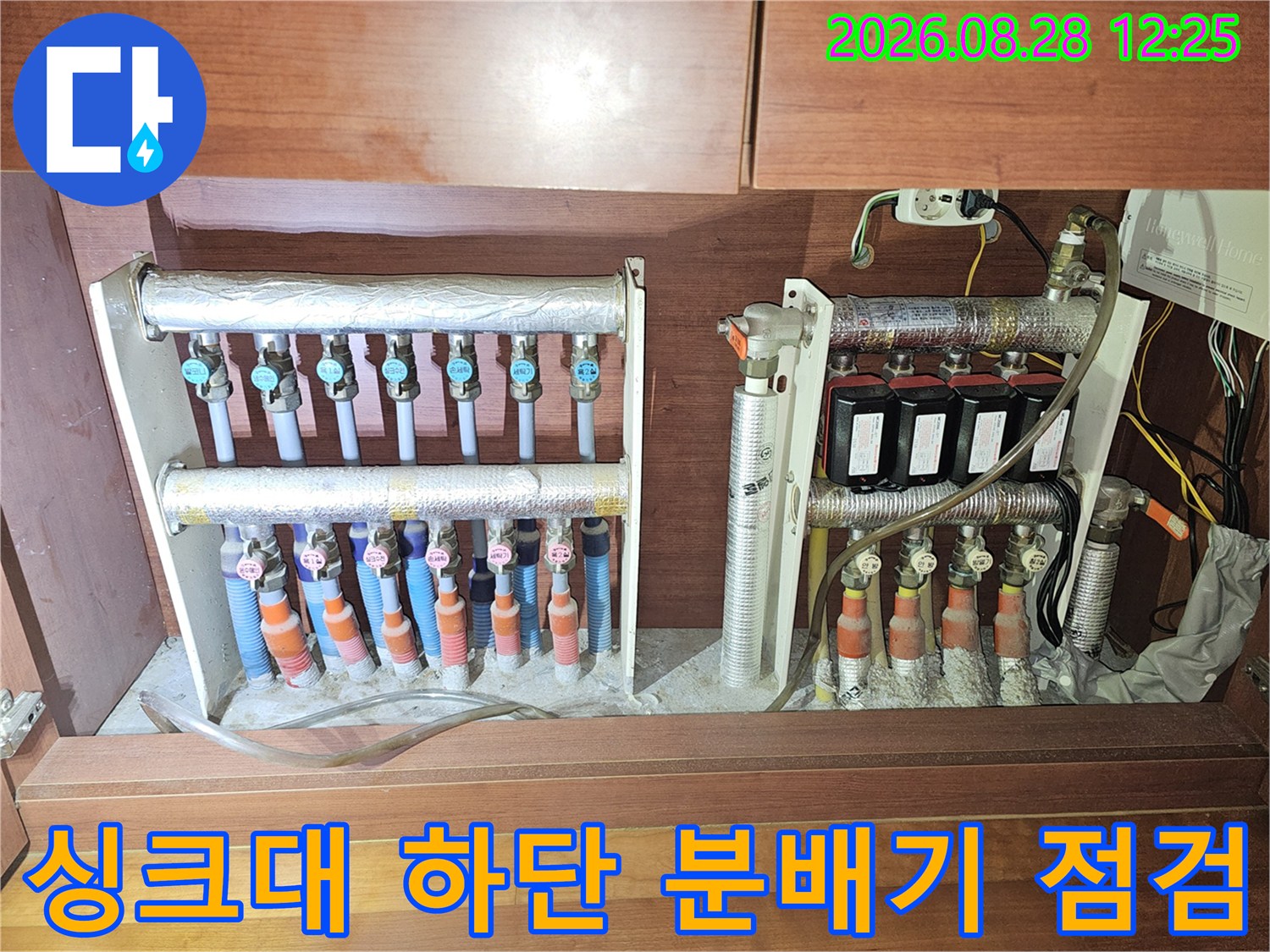 비산동 아파트 싱크대 밑에 설치된 보일러 분배기와 연결 배관들의 모습입니다.