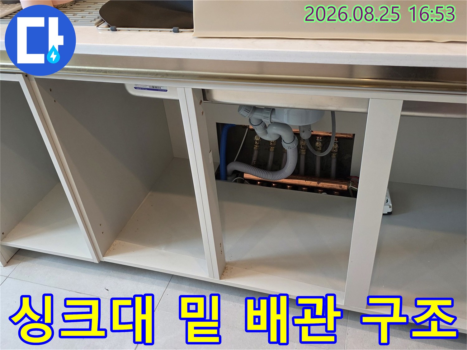 싱크대 하부장 아래쪽의 복잡한 배수관 연결 상태를 근접하여 촬영하였습니다.
