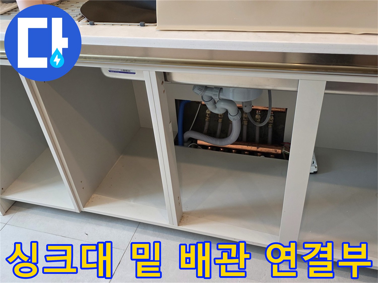 주방 싱크대 하부장의 배수 관로와 연결 부속 상세 이미지입니다.