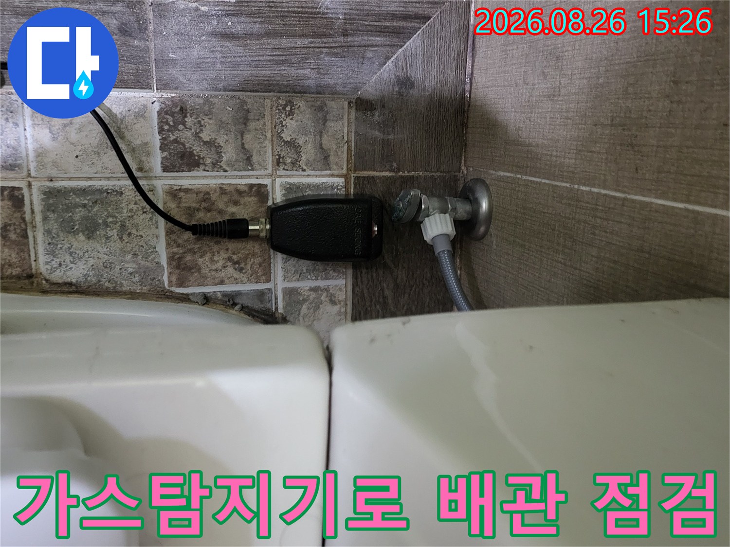 변기 하단 배관 부근에서 가스 탐지기를 사용하여 누수를 정밀하게 측정하고 있습니다.