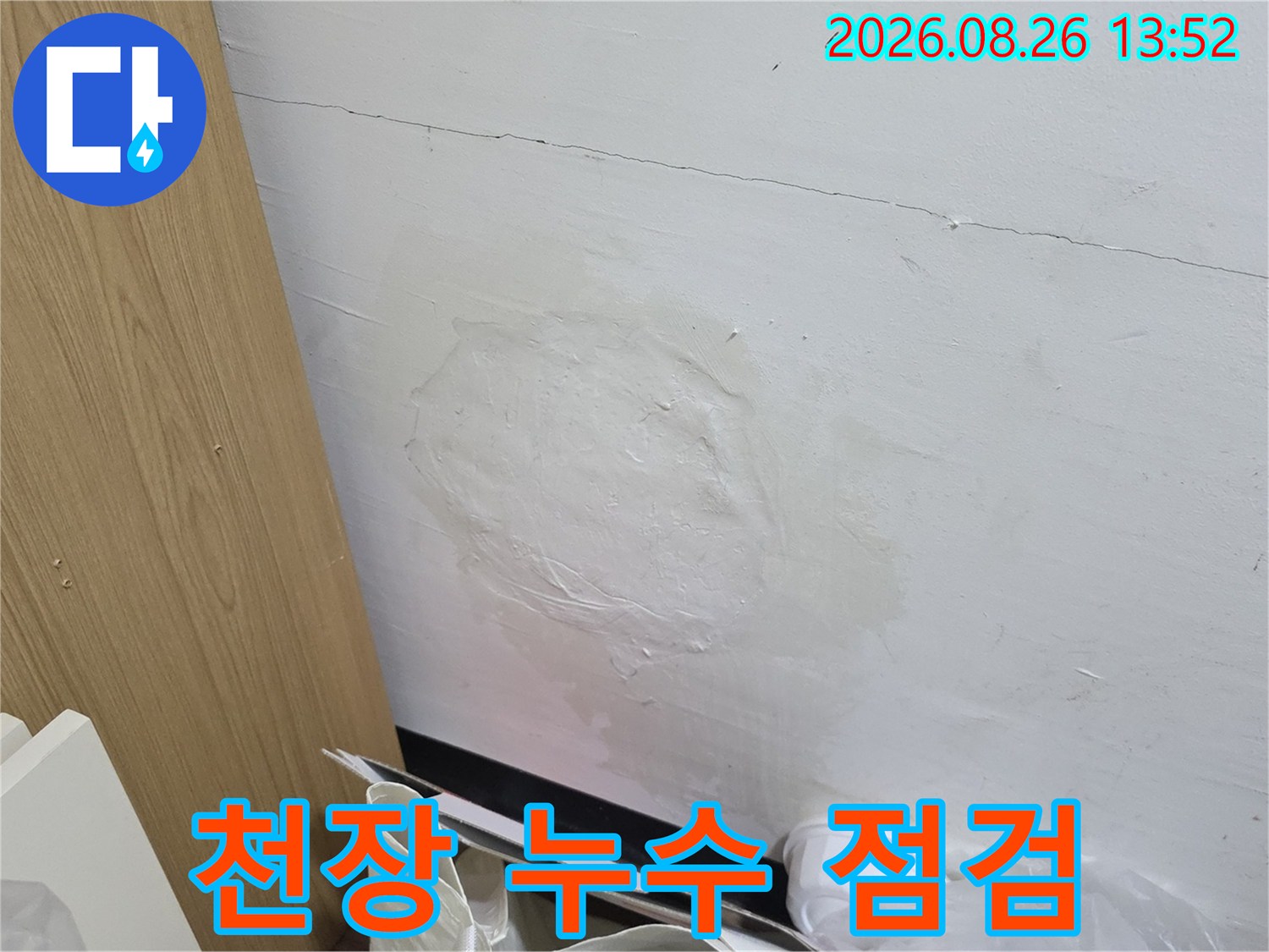 누수 원인 파악을 위해 확인 중인 천장 벽지 얼룩 부위