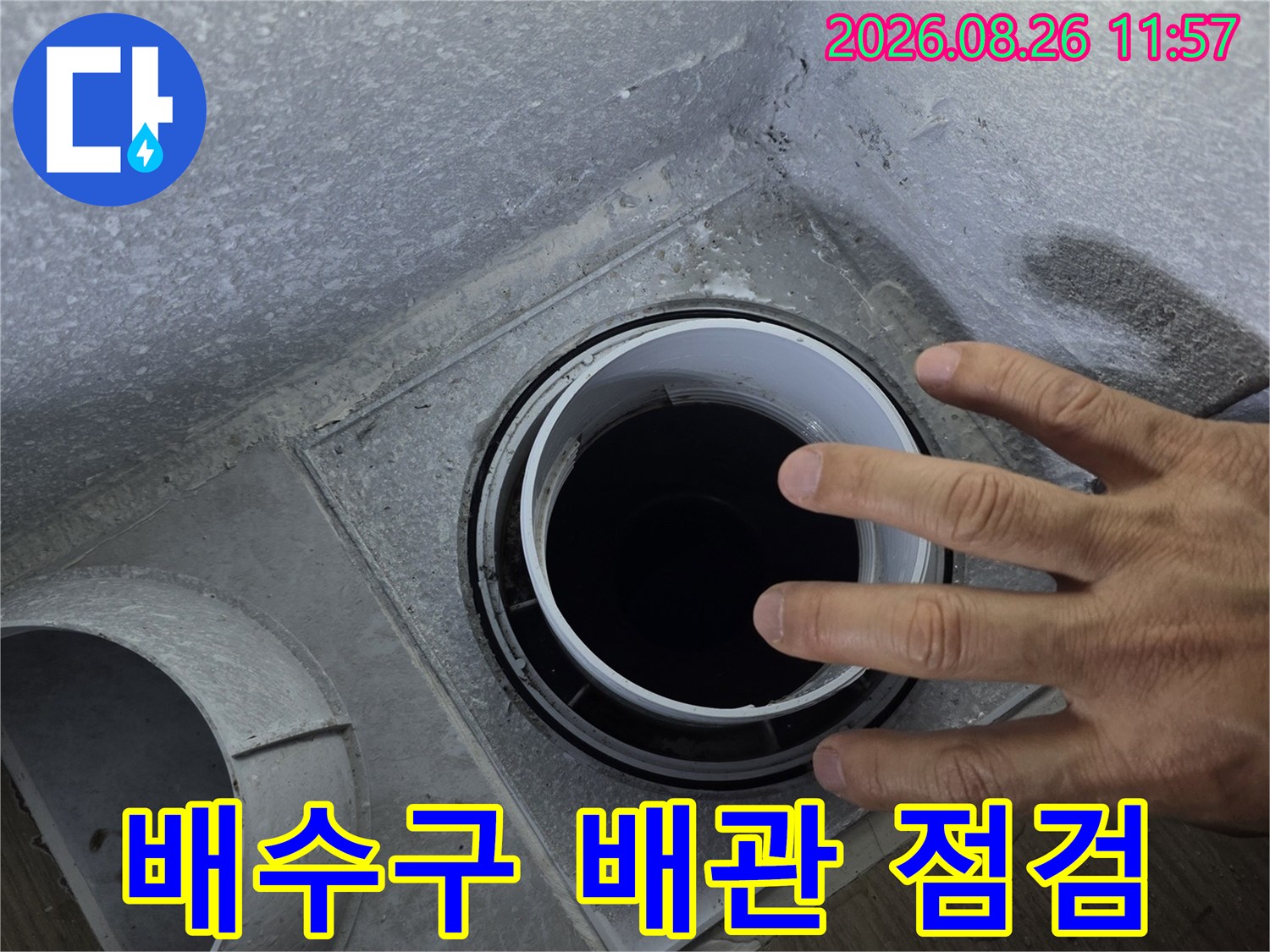 누수가 발생한-배수관 주변의 틈새를 손으로 확인하는 사진입니다.
