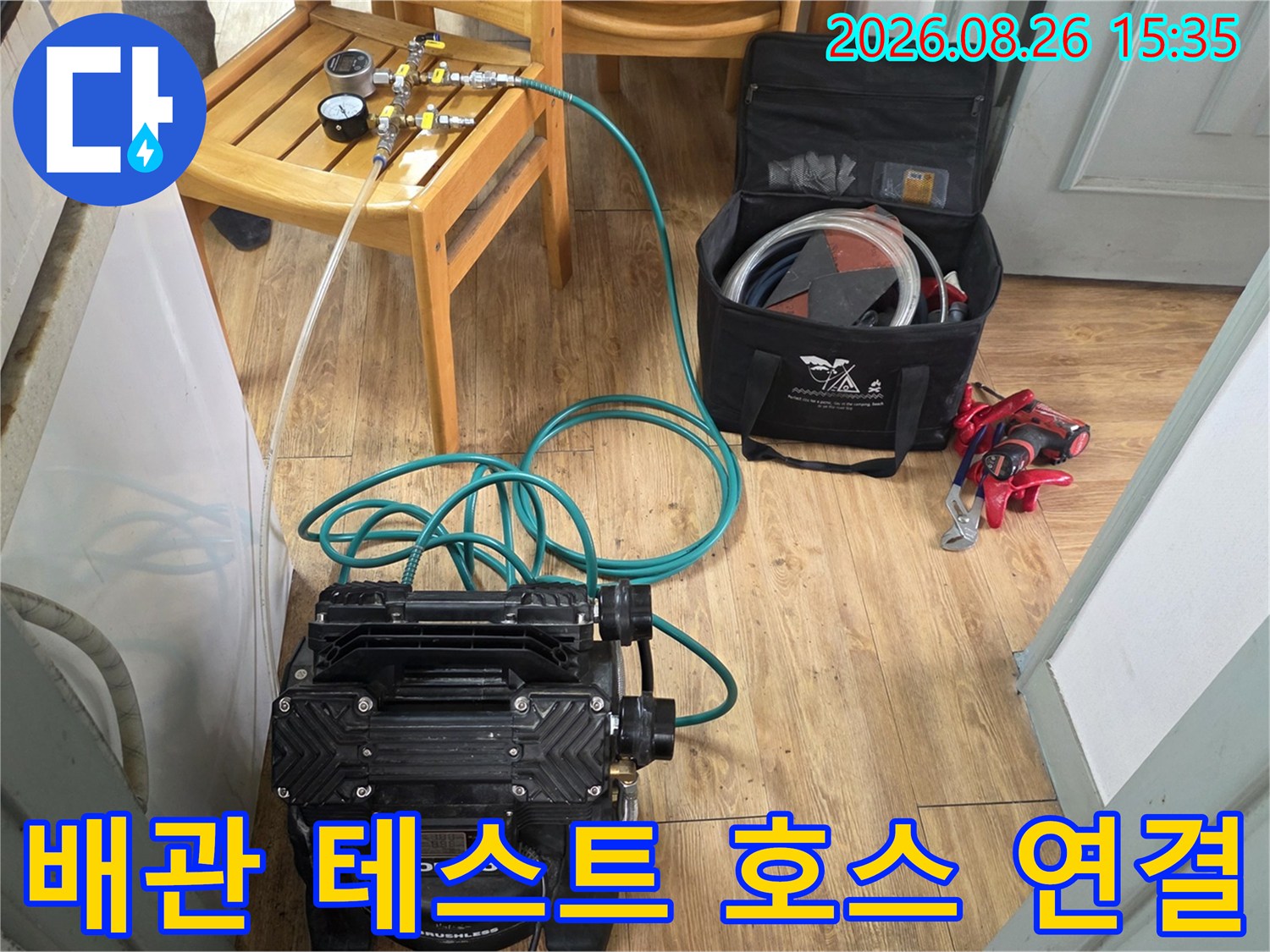 바닥에 놓인 압력계와 배관 연결을 위한 공기 주입용 호스입니다.
