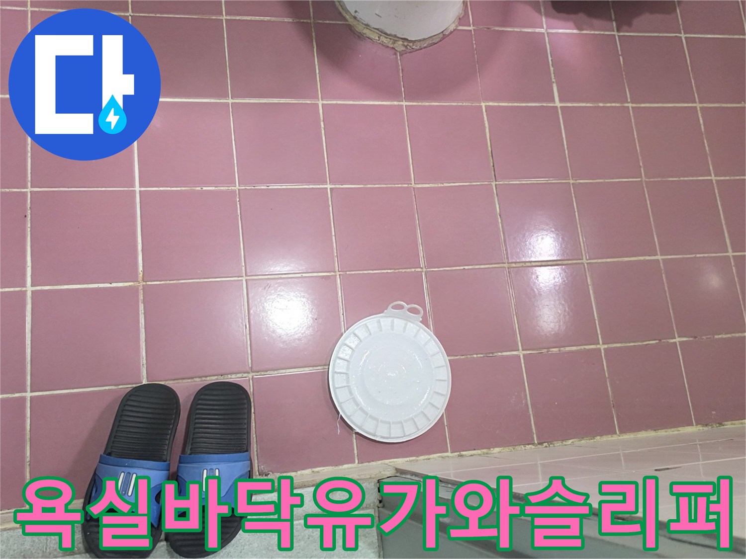 분홍색-타일-바닥에-놓인-하얀색-배수구-덮개와-파란색-슬리퍼