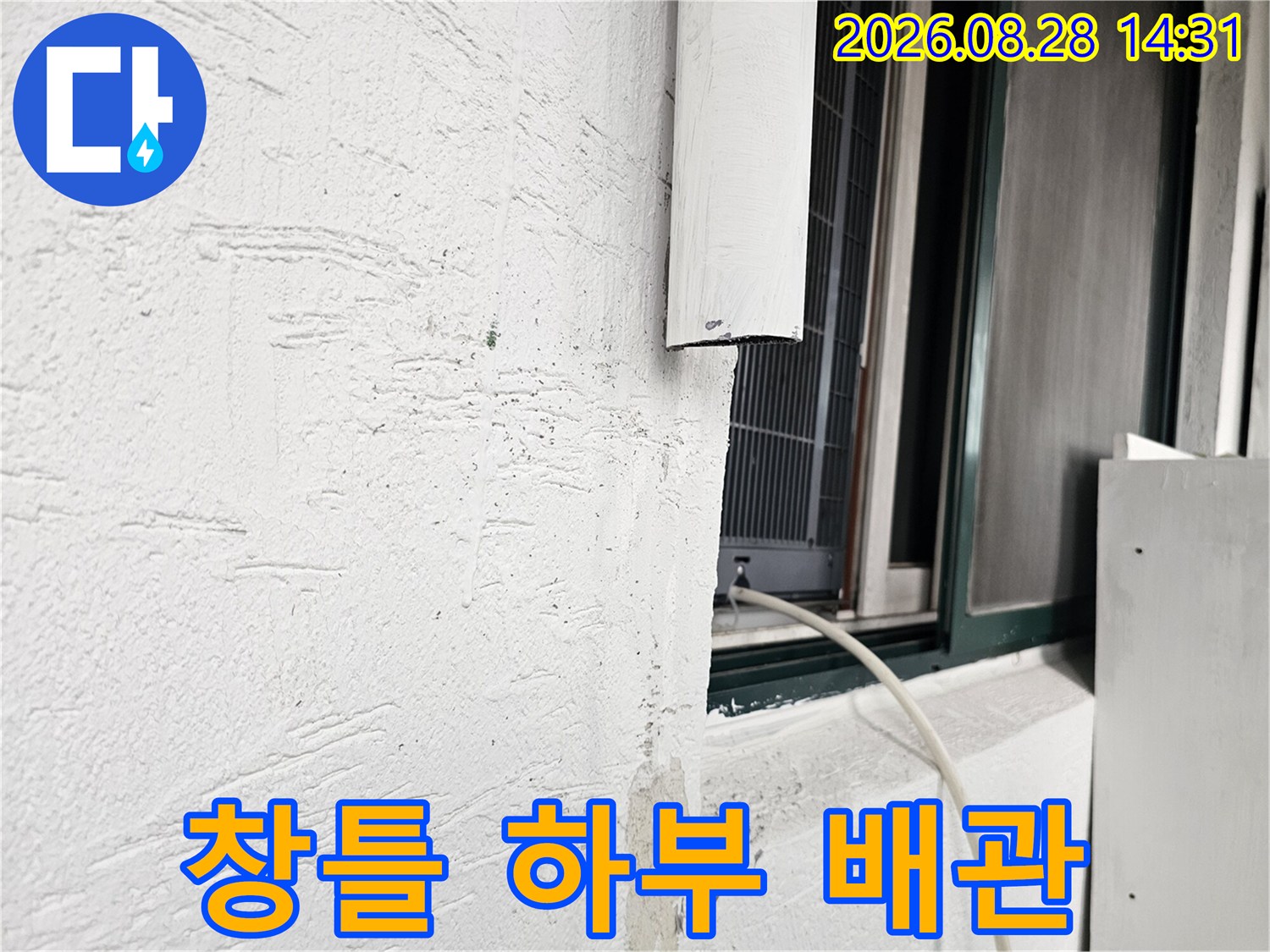 창틀 아래쪽 벽면에 설치된 흰색 배관 상세 사진