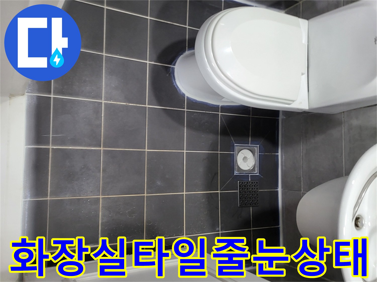 중산동 화장실-어두운색 타일과 배수구 주변 모습
