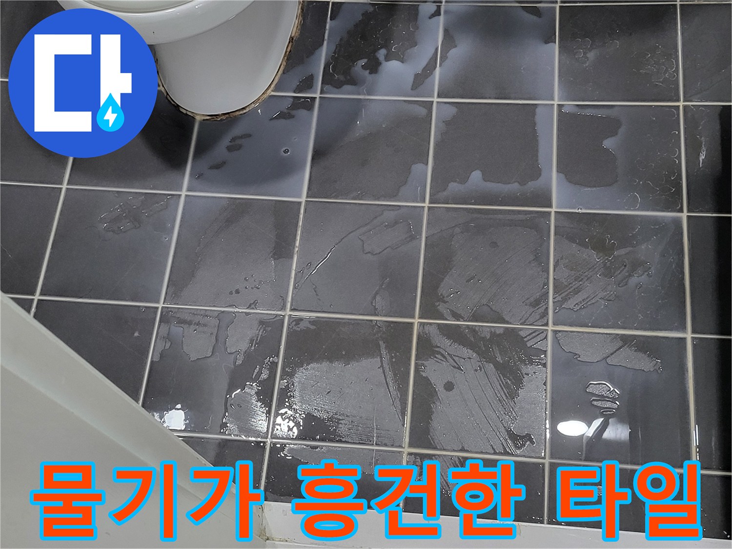 회색 타일 표면에 얇게 물이 고여 있는 모습