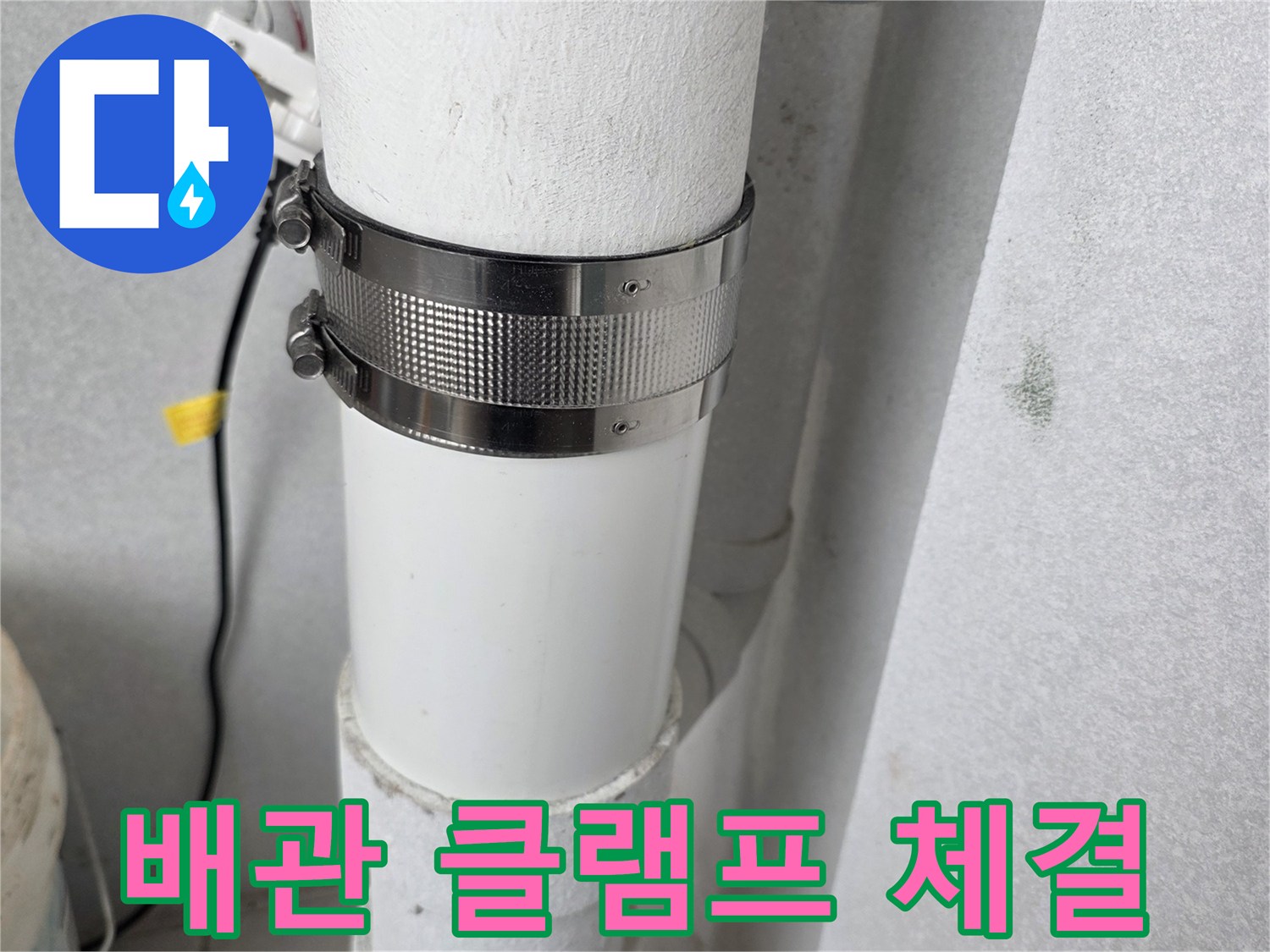 금속 클램프로 고정된 우수관 배관의 연결 구간 근접 촬영