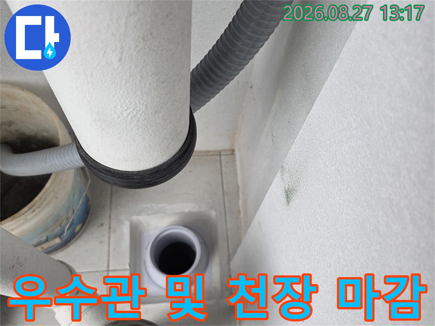 천장 마감재와 연결된 우수관 배관의 근접 촬영 사진