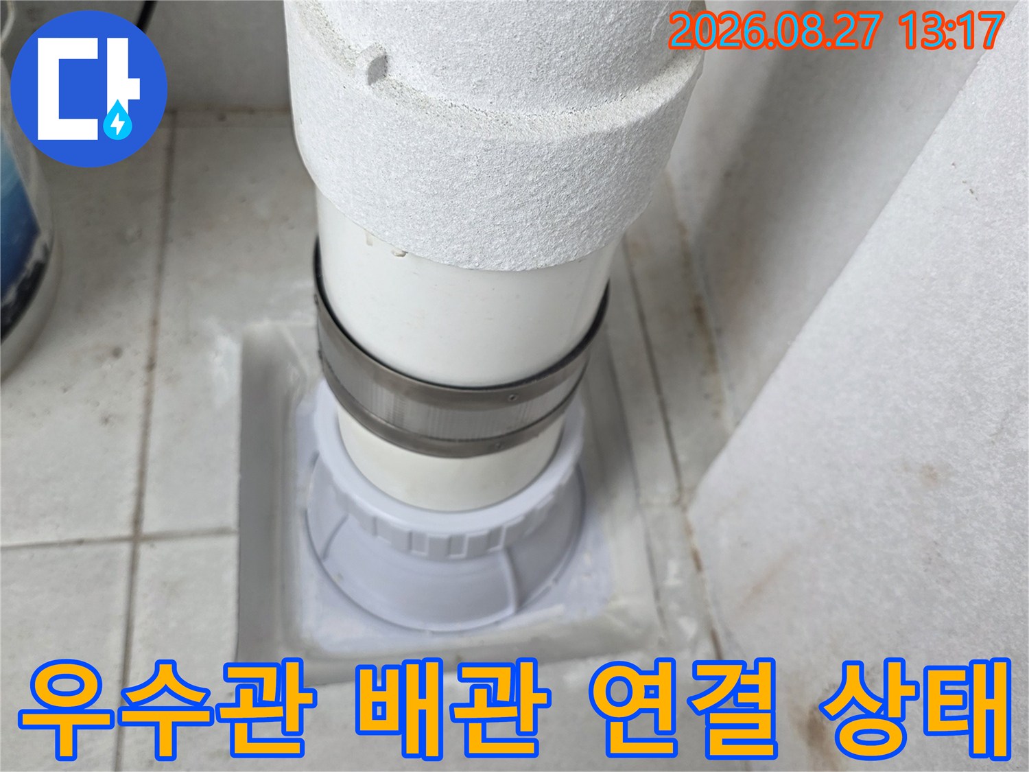 하얀색 우수관 배관과 벽면 타일 접합 부위의 모습