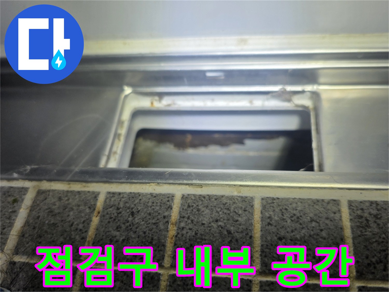 욕실 점검구 안쪽의 배관 및 구조물 근접 촬영입니다.
