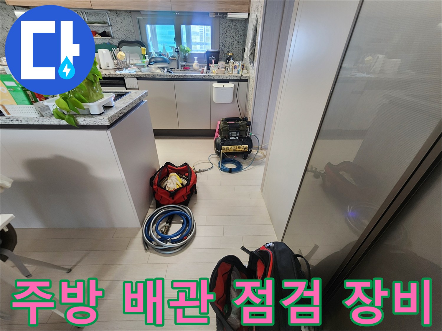 싱크대 아래 공간에 배치된 누수 탐지용 압력 게이지와 호스 세트