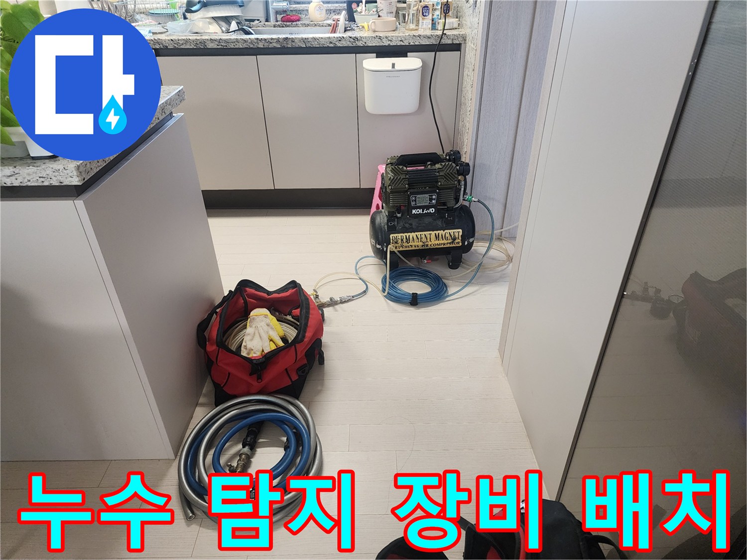 싱크대 아래 공간에 설치된 누수 진단용 압력 조절 장치와 호스
