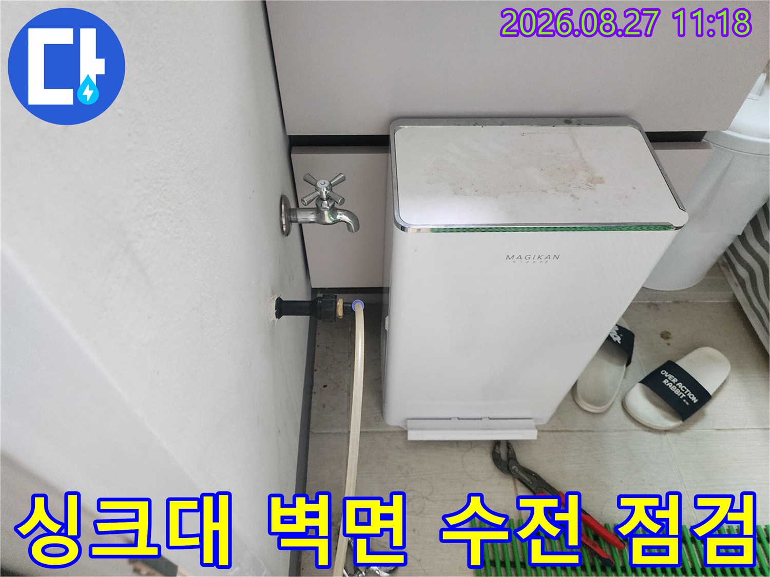 싱크대 아래 벽면에 설치된 수도 밸브와 연결 배관 모습