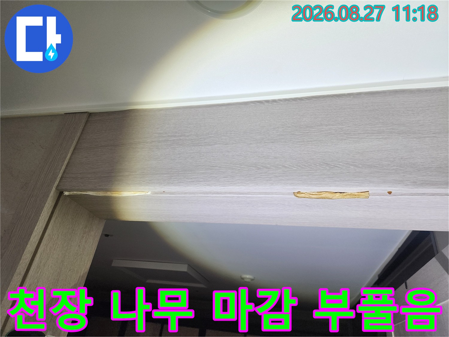 중랑구 아파트 안방 문 위쪽 천장 목재 마감재가 누수로 인해 갈색으로 변색되고 부풀어 오른 모습