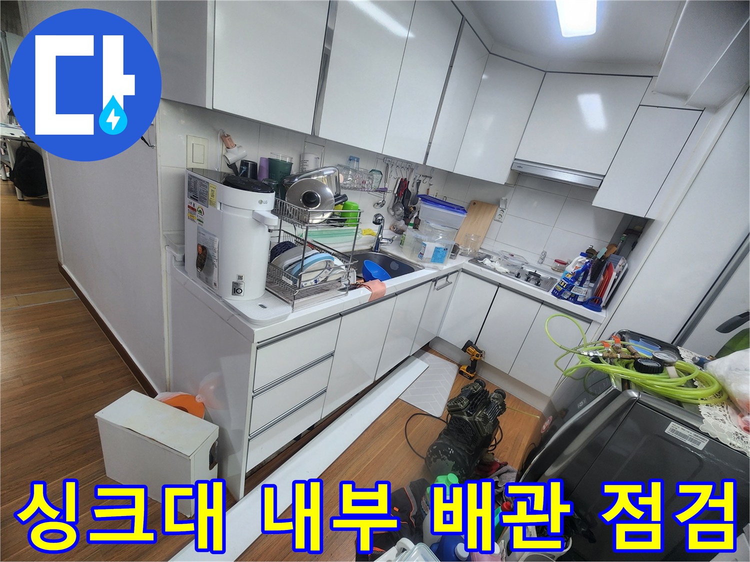 주방 싱크대 하단 수납공간과 배관 주변의 작업 환경
