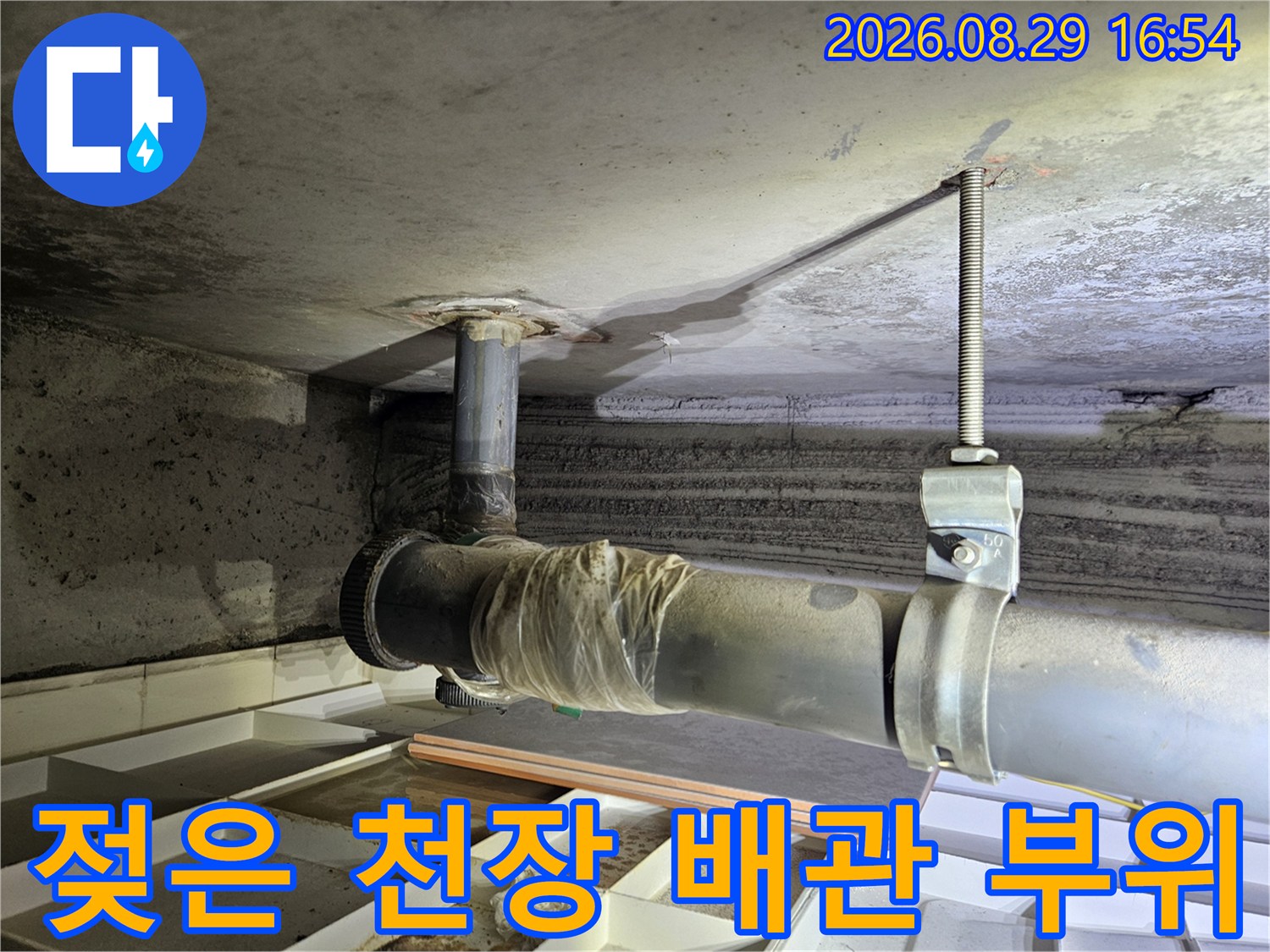 배관 하부 천장-물에 젖어 변색된 콘크리트와 배관 연결부
