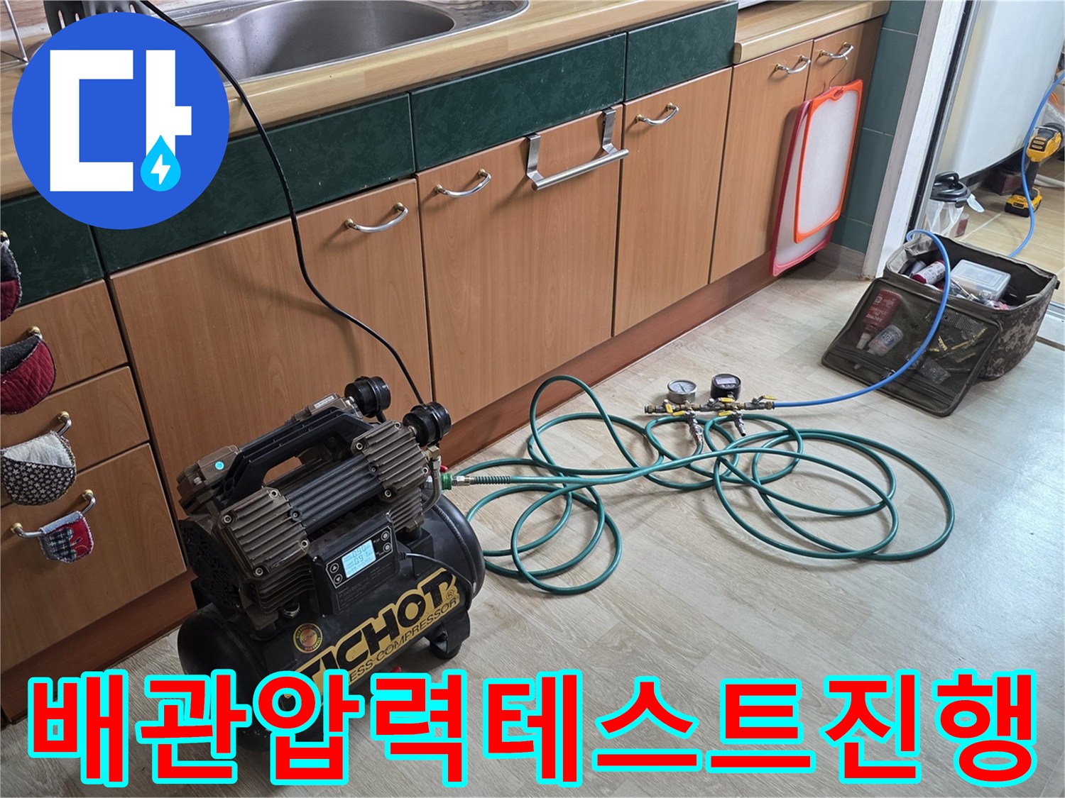 공압 테스트기를 싱크대 하부 배관에 연결하여 압력을 주입하는 모습