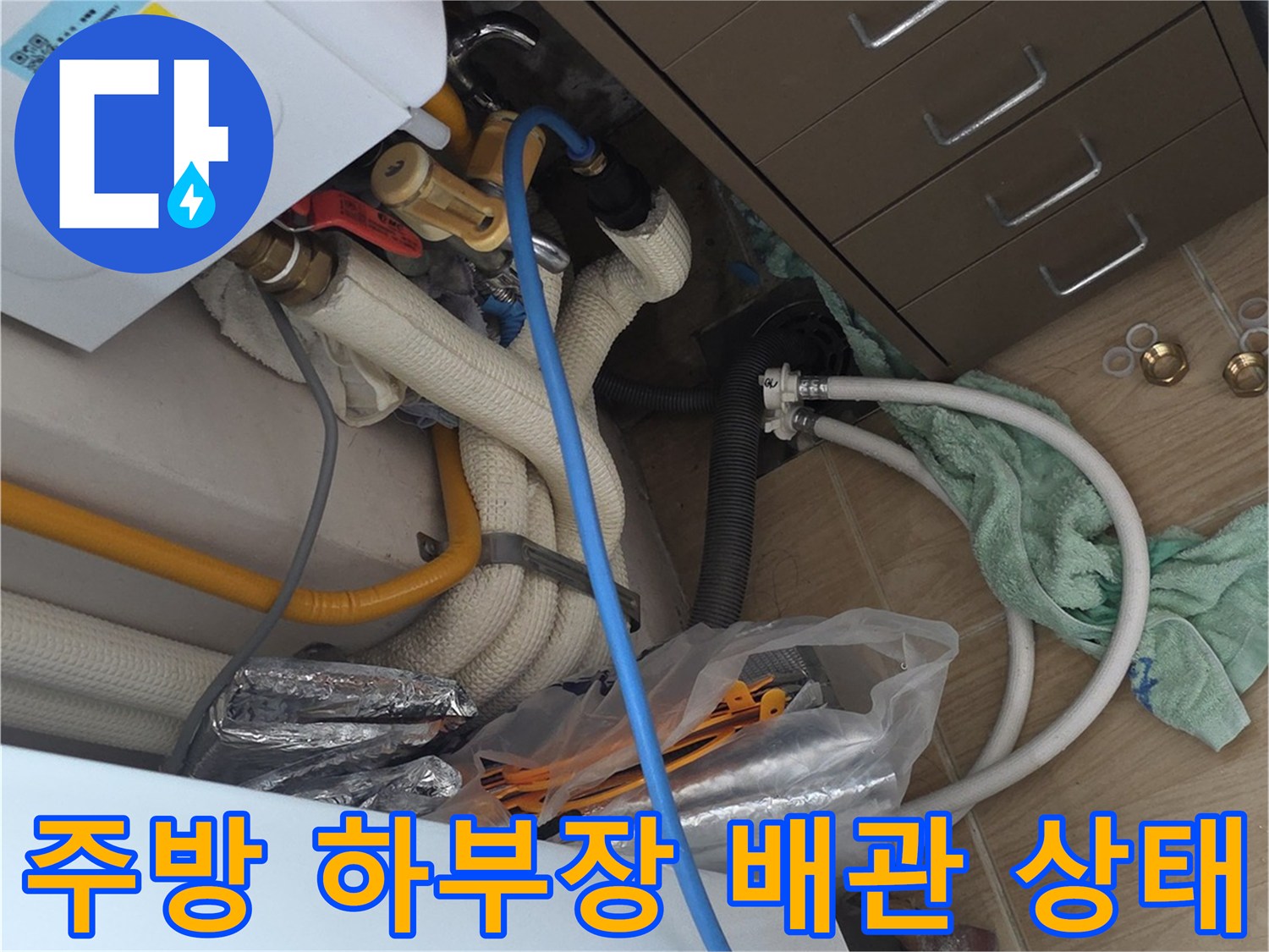 복잡하게 연결된 싱크대 아래쪽 수도 배관과 분배기 모습
